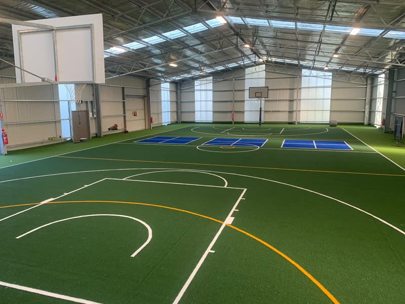 Large indoor hall with line-marked synthetic turf